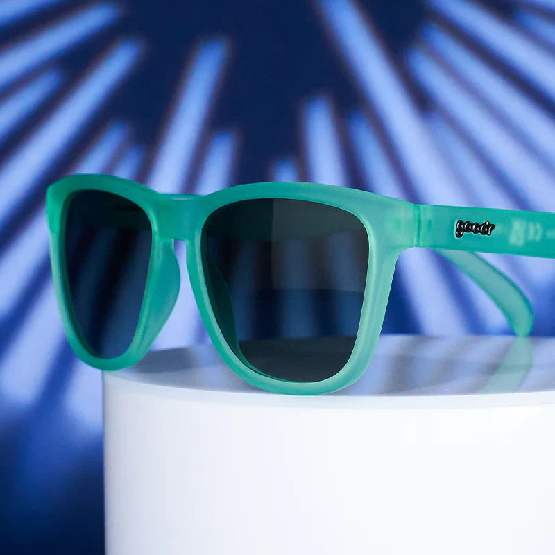 Product shot of mint green square-shaped sunglasses with gradient lenses.